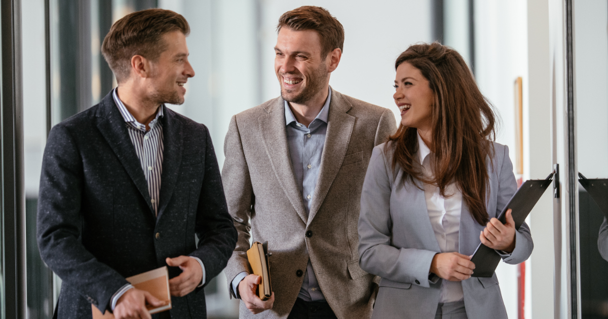 company culture examples image featuring three coworkers smiling and talking