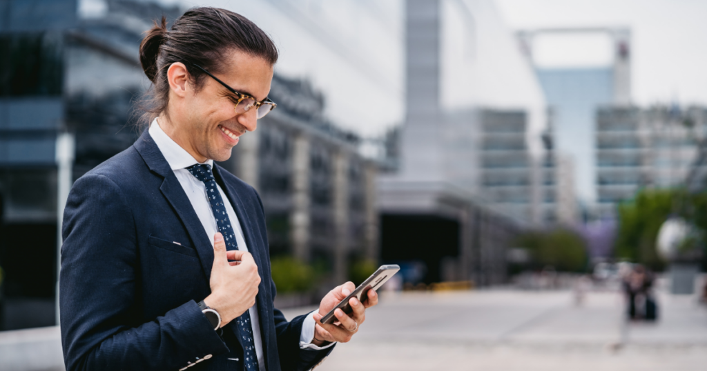 Man smiling at smart phone in depiction of inspirational quotes for employees