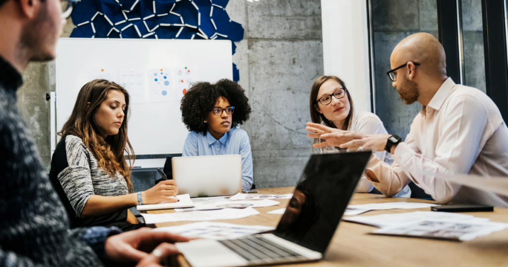 lack of communication in the workplace image featuring workers talking at a desk