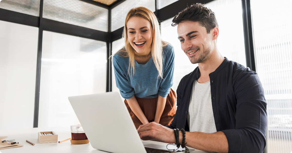 Respect in internal communications image showing two people at work smiling at a computer