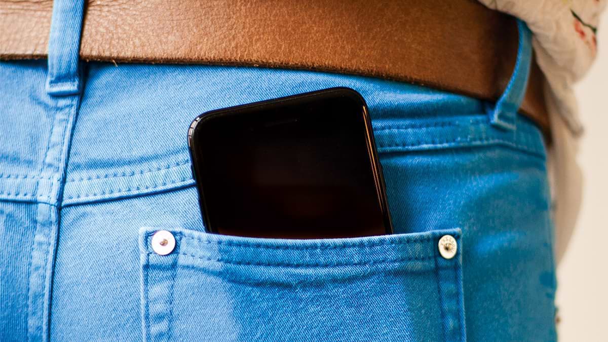 A picture of a smartphone in a jeans pocket