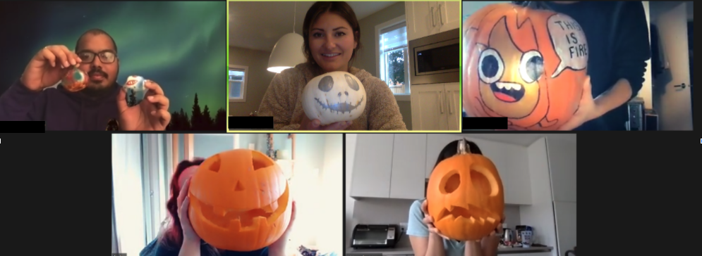 five employees lifting painted and carved pumpkins to the camera to show them off