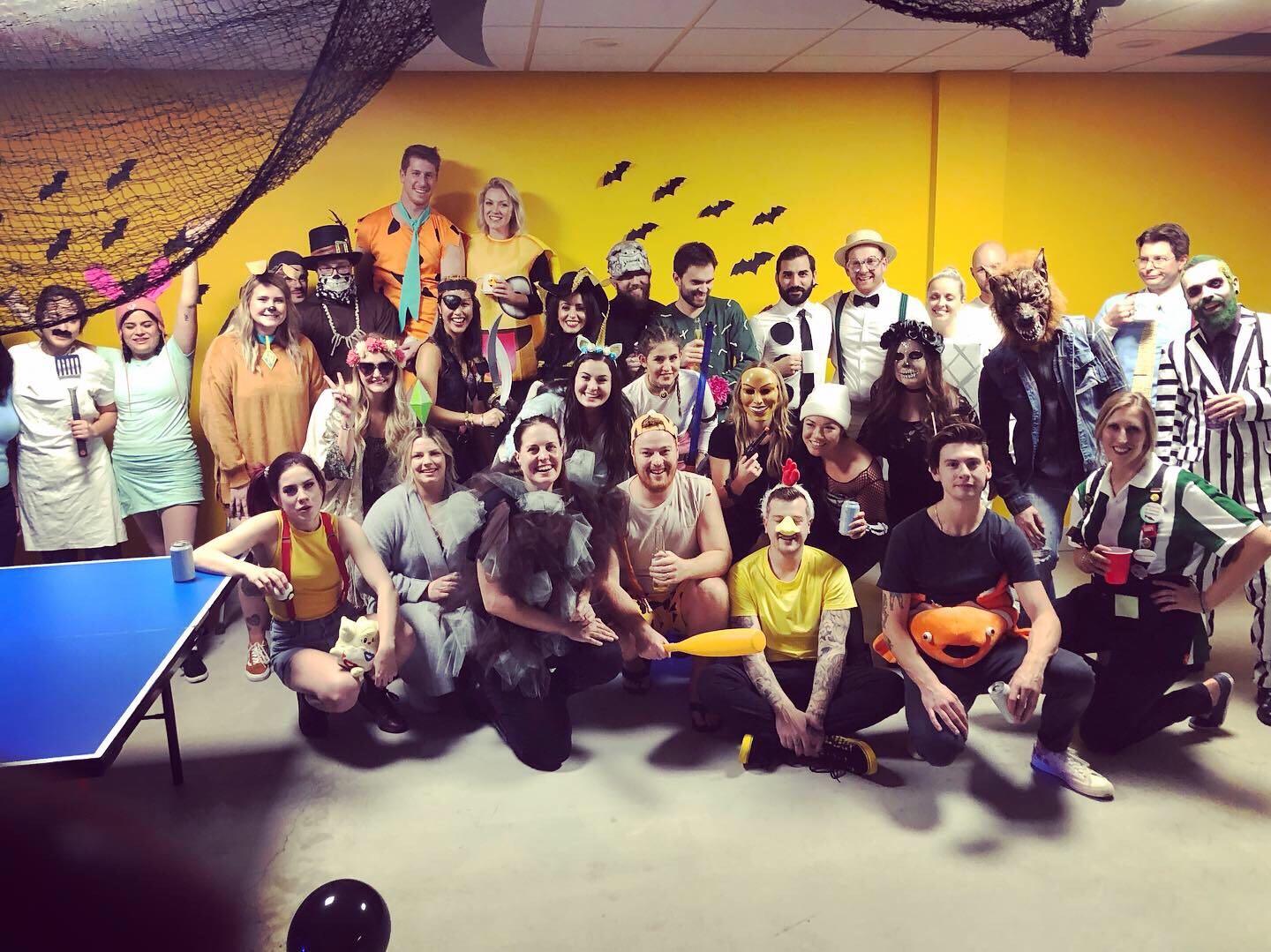 group of people in costume at a company halloween party posing