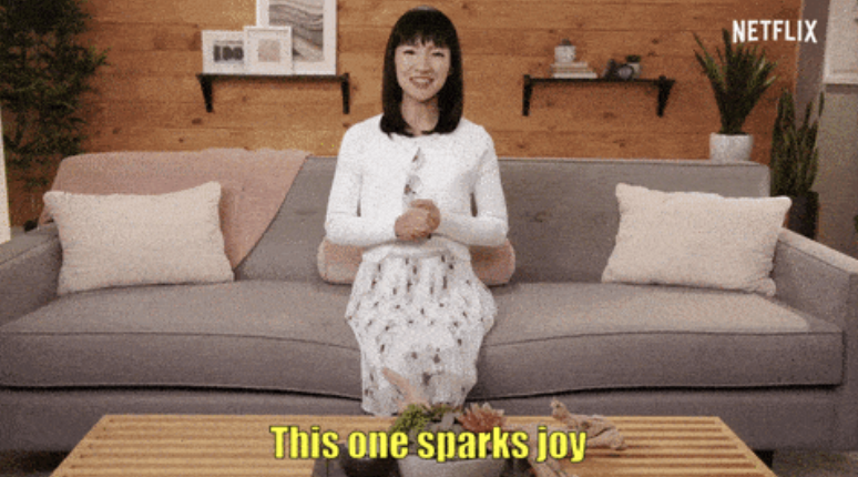 Marie Kondo sits on a couch smiling and says, "This one sparks joy."