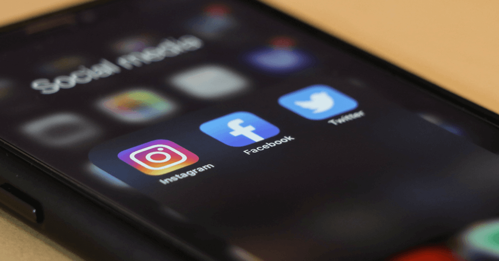 Ein Smartphone-Bildschirm mit den Social-Media-App-Icons von Instagram, Facebook und Twitter.