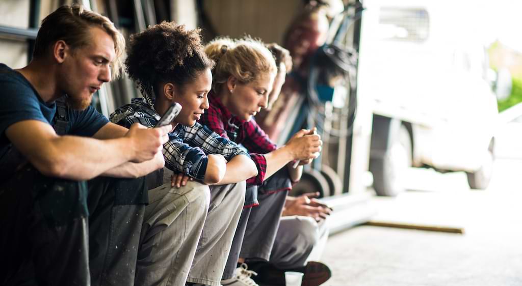 An illustration of young workers glued to their smartphones.