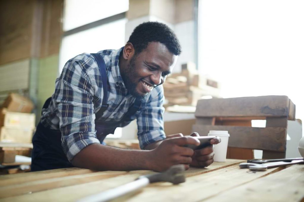 A worker checking his employee communication app demonstrating inspirational message from CEO to staff example.