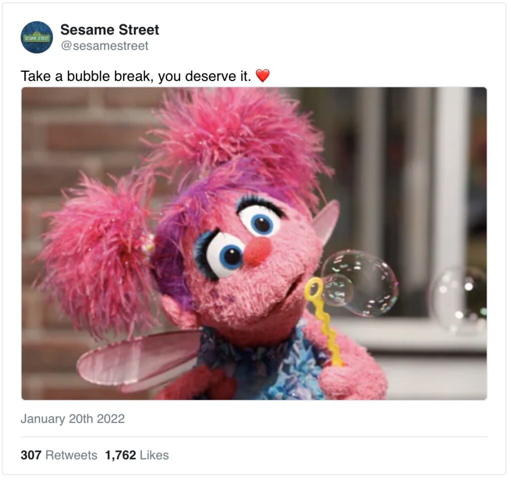 Sesame Street character Abby Cadabby blows bubbles through a wand. 