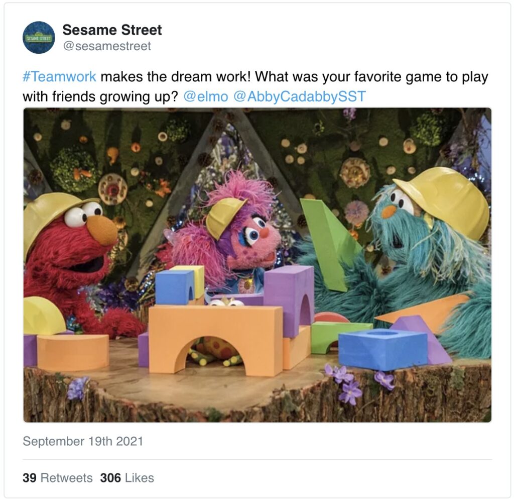 Muppets wearing hard hats play with blocks to build a structure together.