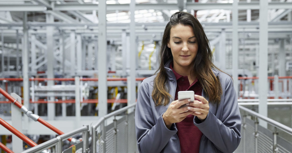 Woman at work using internal communication software on her smartphone.